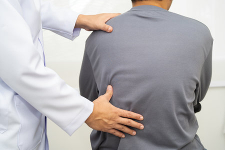 Physical therapy, Asian therapist doctor treat perform pain young man in hospital.