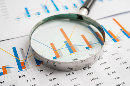 Magnifying glass on charts graphs paper. Financial development, Banking Account, Statistic,...