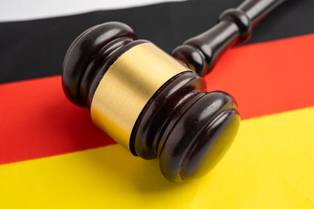 Germany, Legal, justice and agreement, wooden court gavel on flag.の写真素材
