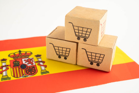 Shopping cart box on Spain flag, import export, finance commerce.の写真素材