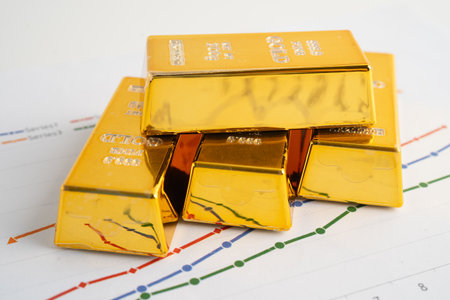 Gold bars on graph paper, finance trading investment business currency.