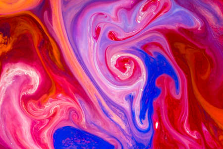 Watercolor paints of different colors are poured into a white containerの写真素材