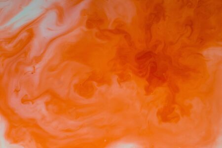 Watercolor paints of different colors are poured into a white containerの写真素材