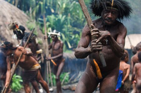 The Papuan banishes from the village, swinging a stick.のeditorial素材
