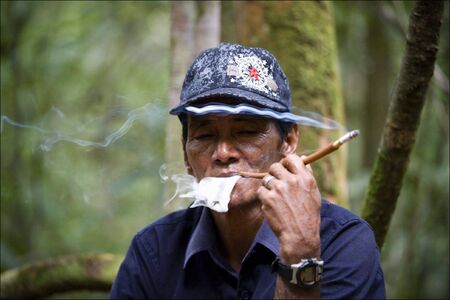 Umar - the Indonesian guide, smokes a cigaret. Wood of Borneo. Indonesia. On May, 4th, 2008. Indonesia. Borneoのeditorial素材
