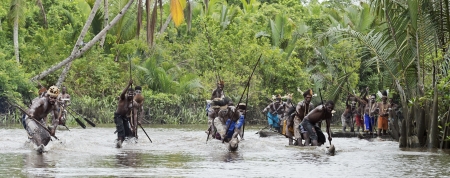 INDONESIA, IRIAN JAYA, ASMAT PROVINCE, JOW VILLAGE - JUNY 28:  Asmat men paddling in their dugout canoe. Canoe war ceremony of Asmat people. Headhunters of a tribe of Asmat show traditional and national customs, dresses, the weapon and boats. New Guinea Iのeditorial素材