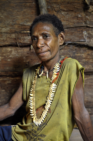 ONNI VILLAGE, NEW GUINEA, INDONESIA - JUNE 24: The Portrait Korowai woman in the wood house. Korowai Kombai ( Kolufo).On June 24, 2012 in Onni Village, New Guinea, Indonesiaのeditorial素材