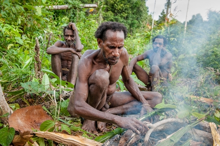 ONNI VILLAGE, NEW GUINEA, INDONESIA - JUNY 24: The Korowai man it suggests to be treated cooked sago worms ( larvae insect ). June 24, 2012 in Onni Village, New Guinea, Indonesiaのeditorial素材