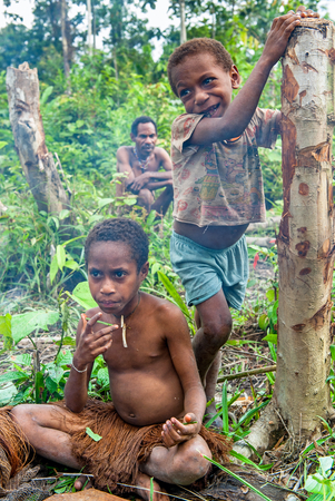 WILD JUNGLE, IRIAN JAYA, NEW GUINEA, INDONESIA - JUNE 24 2012: Papuan little children of Korowai tribe in the jungle of New Guinea Island. Onni Village.のeditorial素材