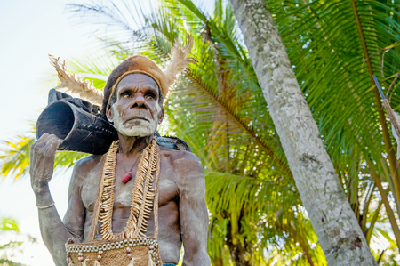 JOW VILLAGE, ASMAT, NEW GUINEA, INDONESIA - JUNE 28: Leader of Asmat tribe with drum (em). The In the village of Asmates goes preparation for of aceremony. June 28, 2012, Jow Village, Asmat, Indonesiaのeditorial素材