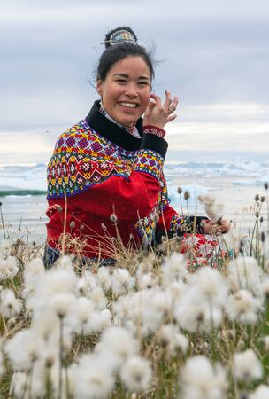 Ilulissat, Greenland - July 11, 2018: Young inuit woman in traditional clothing posing for photos in a small Greenlandish village.のeditorial素材