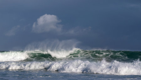 Seascape. Powerful ocean wave on the surface of the ocean. Wave breaks on a shallow bank. Stormy weather, stormy clouds sky background.の写真素材