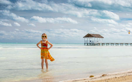 Cute little girl on sandy beach in sunset light. Cuba. Caya Coco.