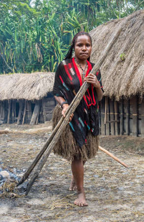 BALIEM VALLEY, WEST PAPUA, INDONESIA, JUNE 16th, 2016: Portrait of young woman from Dugum Dani tribe people with wooden clip for hot stones. New Guinea Island, Iran Jaya, Indonesia on June 16, 2016のeditorial素材