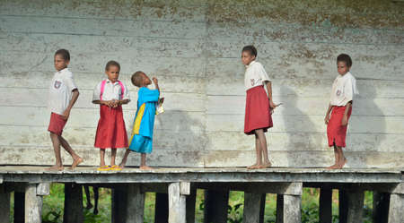 YOUW VILLAGE, ATSY DISTRICT, ASMAT REGION, IRIAN JAYA, NEW GUINEA, INDONESIA - MAY 23, 2016: Schoolchildren in uniform. Small village of the Asmat tribe. New Guinea.May 23, 2016のeditorial素材