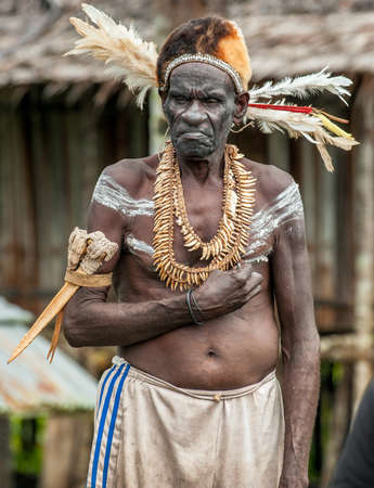 JOW VILLAGE IN JUNGLE, ASMAT DISTRICT, NEW GUINEA, INDONESIA - JUNE 14: Portrait of Headhunter of a...