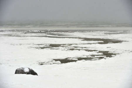 Snow, ice, hummocks on snow-covered ice of lake. A natural winter background