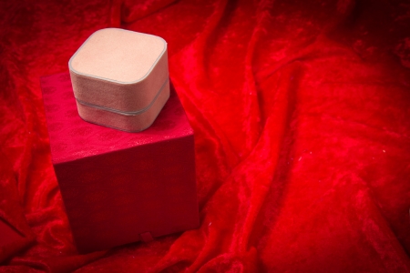 A variety of luxurious red jewelry boxes stacked on velvet background の写真素材