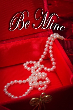 Pearl necklace cascades from jewelry box on red velvet background の写真素材