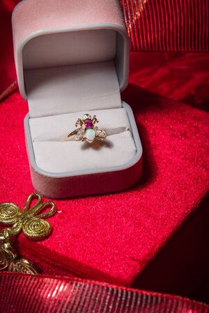 Ring rests in open jewelry box on red velvet backgound.の写真素材