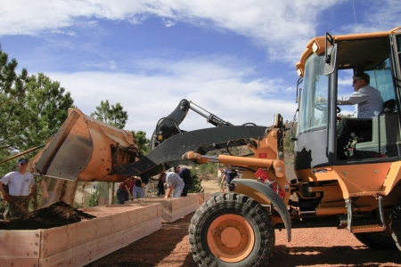 Raised garden beds are being prepared by team of people and front-end loader.のeditorial素材