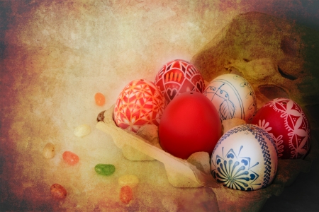 Colorful Easter eggs sit in a carton with jelly beans scattered around with golden texture overlay の写真素材