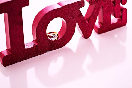 Magenta LOVE block letters with a diamind ring resting in の写真素材