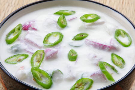 Indian curry accompaniment cucumber raita, made from yoghurt, cucumber, green chili, roasted ground cumin seed.の写真素材