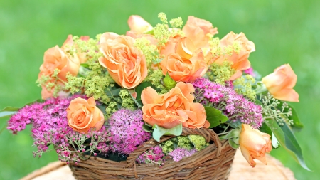 Braided flower basket with roses and spiraea in the gardenの写真素材