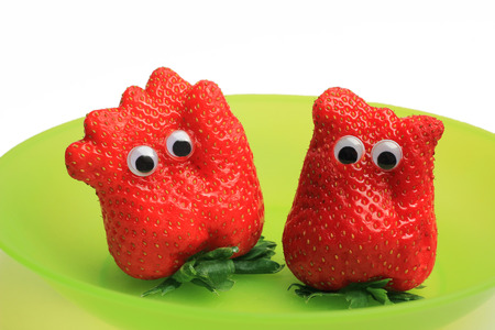 Two funny fresh strawberries with jiggle eyesの写真素材