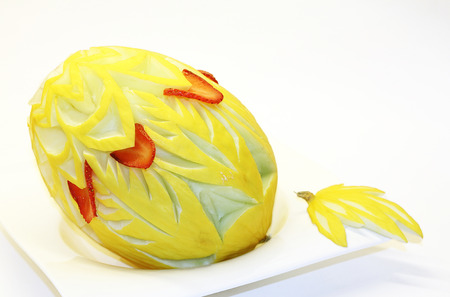 Garnished honeydew melon on a white plateの写真素材
