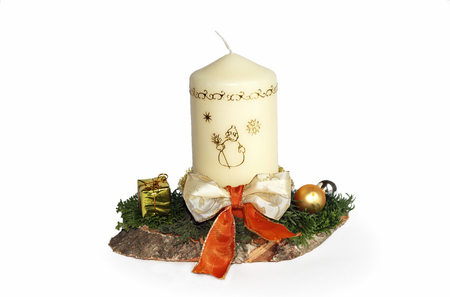 Advent spray with decorated white candle and beautiful ribbon, fresh green twigs on a timber slice, handicraft work selfmadeの写真素材