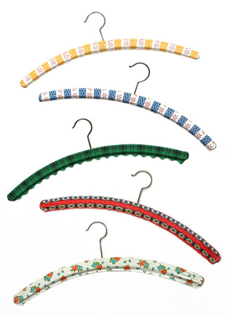 Assortment of nostalgic wooden cloth hangers with patterned colorful plastik coverの写真素材