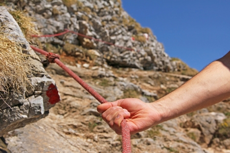 Hand of mountain climber, holding on a climbing ropeの写真素材