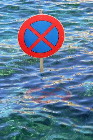 Overflowed street with traffic sign in the waves.の写真素材