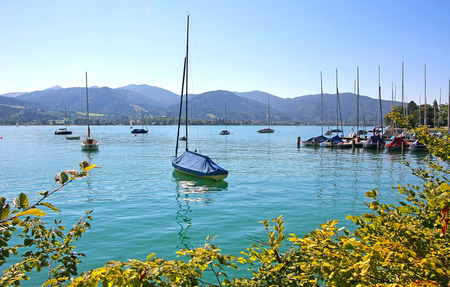 tegernsee lake shore with moored sailing boats, tranquil bavarian sceneryの写真素材