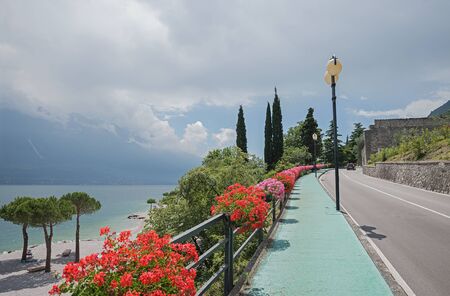 pedestrian walkway along gardesana road and beach limone sul garda, italyの写真素材
