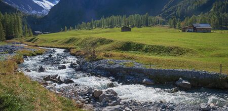 meadow land with cold mountain river, sertig valley in the swiss alps
