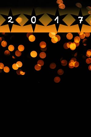 bright orange lens flares on black background - new year 2017, with copy space