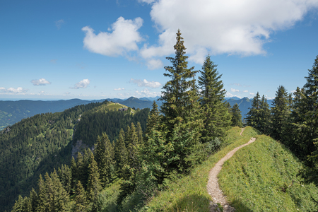 beautiful narrow hiking trail along the mountain crest brauneck, upper bavariaの写真素材