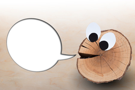funny face with blank speech bubble on wooden backgroundの写真素材