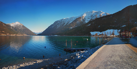 lakeside promenade achensee in autum with first snow at the mountain peaks. tourist destination pertisau, tirolの写真素材