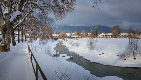 idyllic walkway along loisach riverside in tourist destination garmisch, grey winter day with sunny...