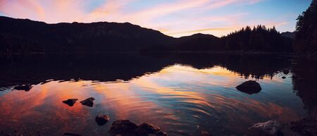 dreamy sunset scenery at lake eibsee with view to famous zugspitze mountain, panorama landscape upper bavariaの写真素材