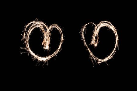 two glowing hearts. light painting at night with a sparkler. creative movement photography, made...