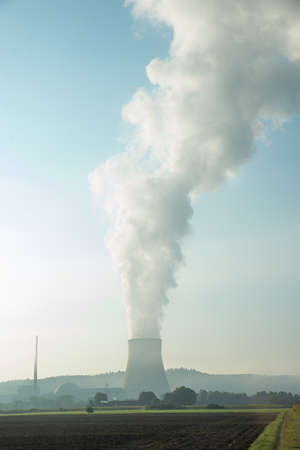 nuclear power srtation with cloud of smoke in the morning sun, vertical format