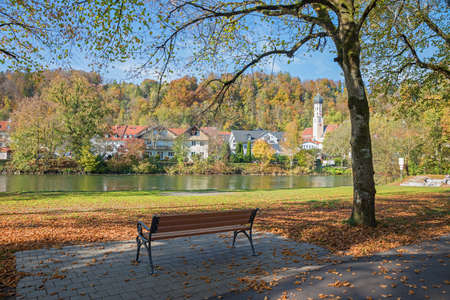 Isar riverside with autumnal trees and bench, spa town Wolfratshausen, beautiful destination upper bavariaの写真素材