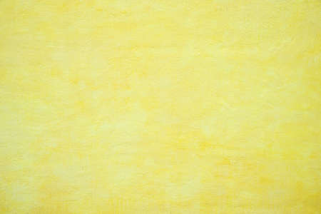 concrete wall structured with spatula technique, yellow sunny easter background