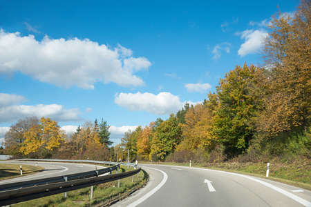 curvy freeway ramp, autumnal landscape upper bavaria, blue sky with clouds