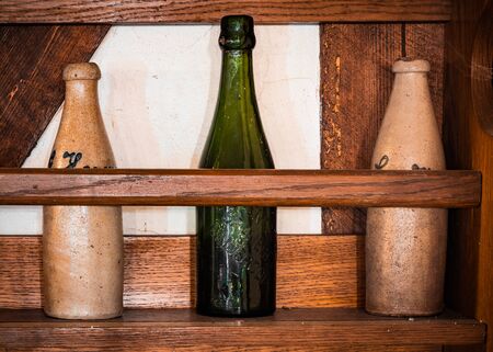 Old beer bottles standing on a shelf in an abandoned country house.の写真素材